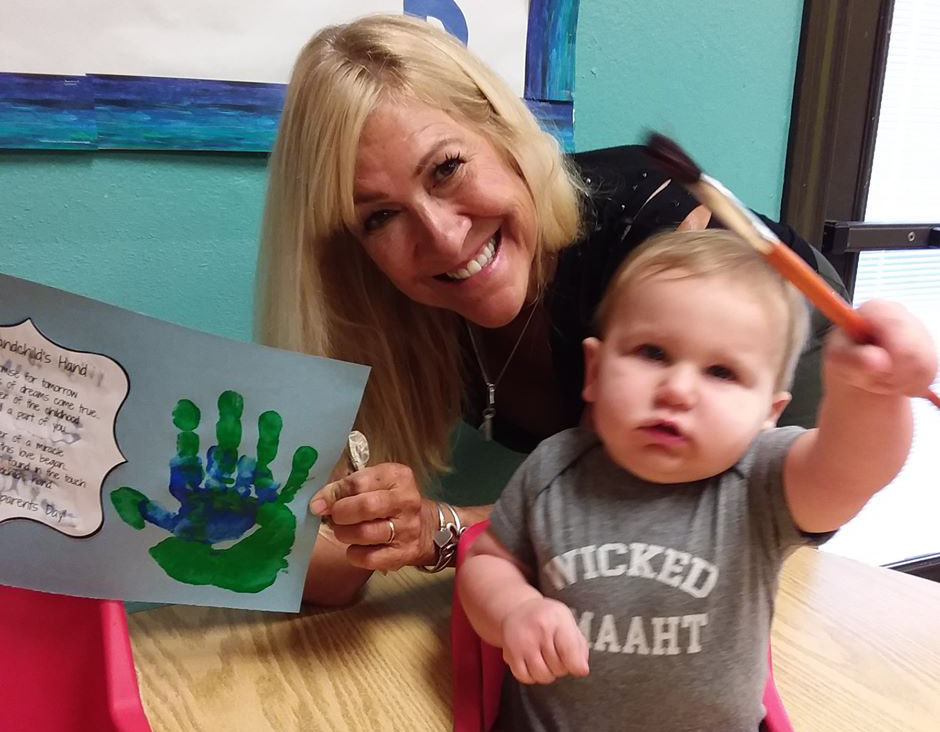 baby playing with paintbrush at a Preschool & Daycare Serving San Antonio, TX
