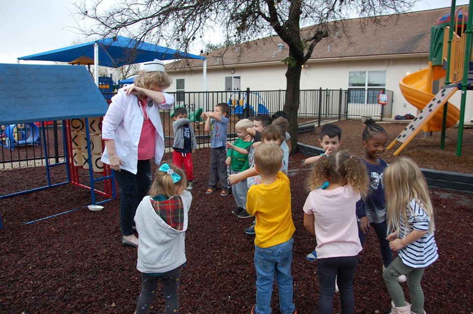 children and teacher playing outside at a Preschool & Daycare Serving San Antonio, TX