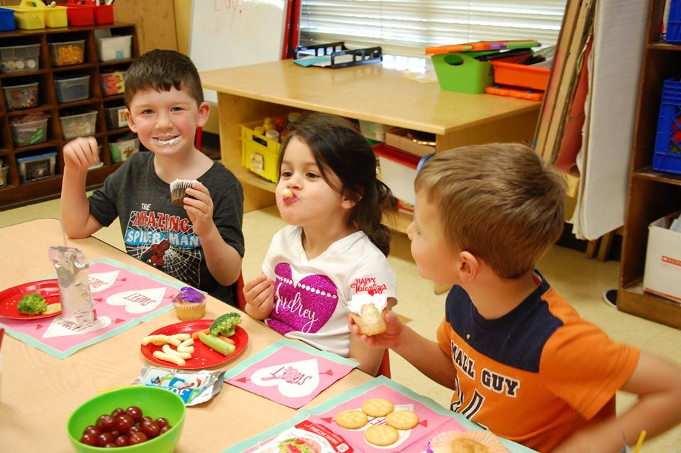 children sitting at a table eating healthy food at a Preschool & Daycare Serving San Antonio, TX