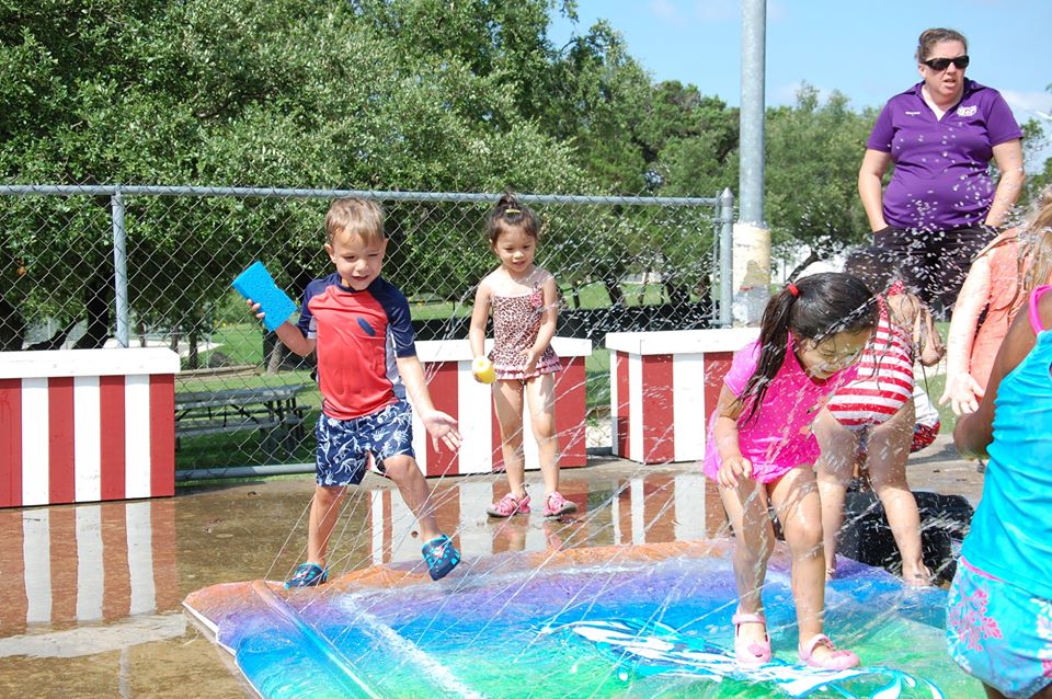 kids enjoying fun in the sun with splash pad at a Preschool & Daycare Serving San Antonio, TX