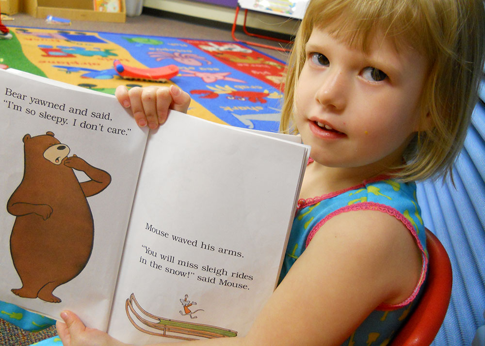 little girl showing off picture book at a Preschool & Daycare Serving San Antonio, TX