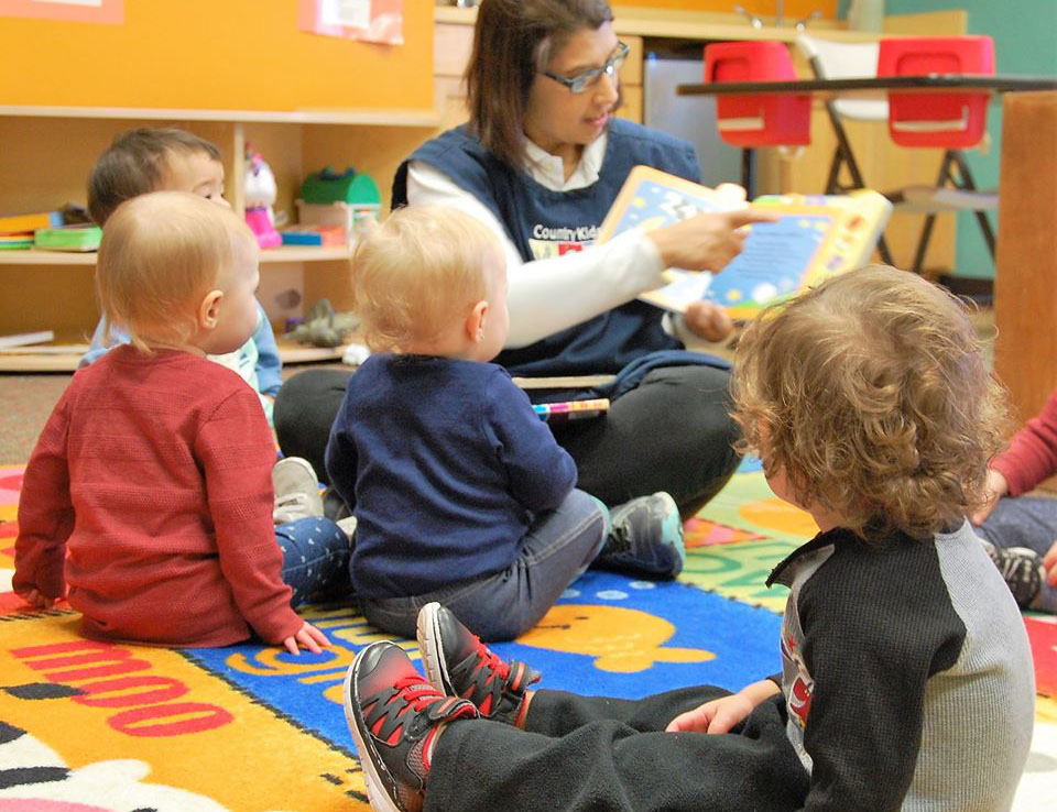 teacher reading to toddlers in class at a Preschool & Daycare Serving San Antonio, TX
